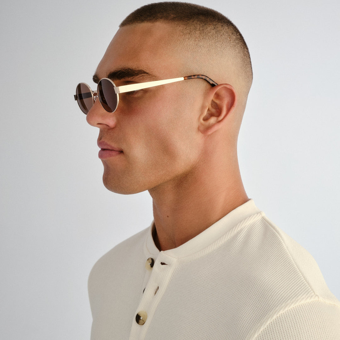 Side profile of male model wearing Norwood sunglasses in Gold