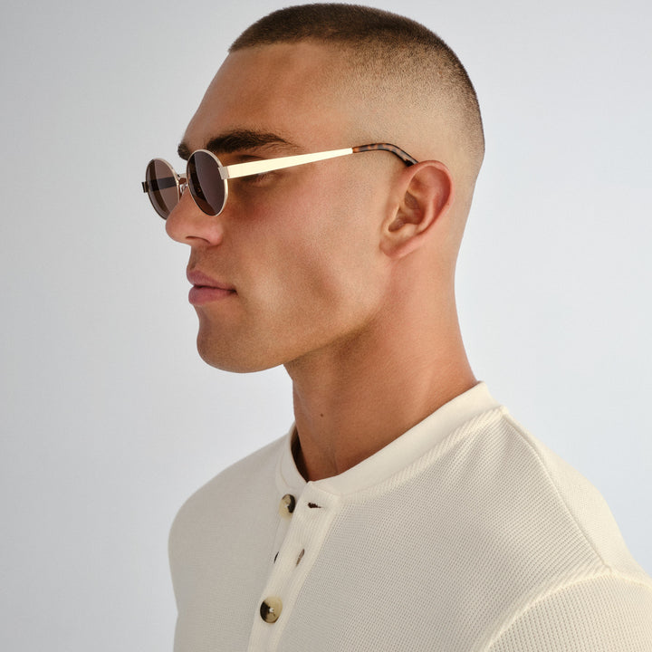Side profile of male model wearing Norwood sunglasses in Gold