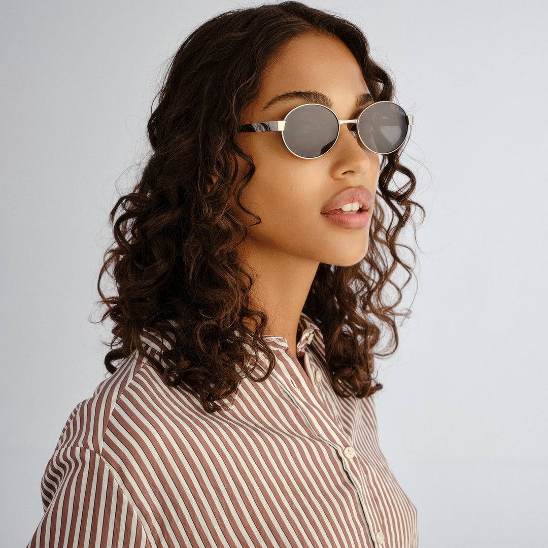 Female model wearing Norwood sunglasses in Gunmetal, three‑quarter angle