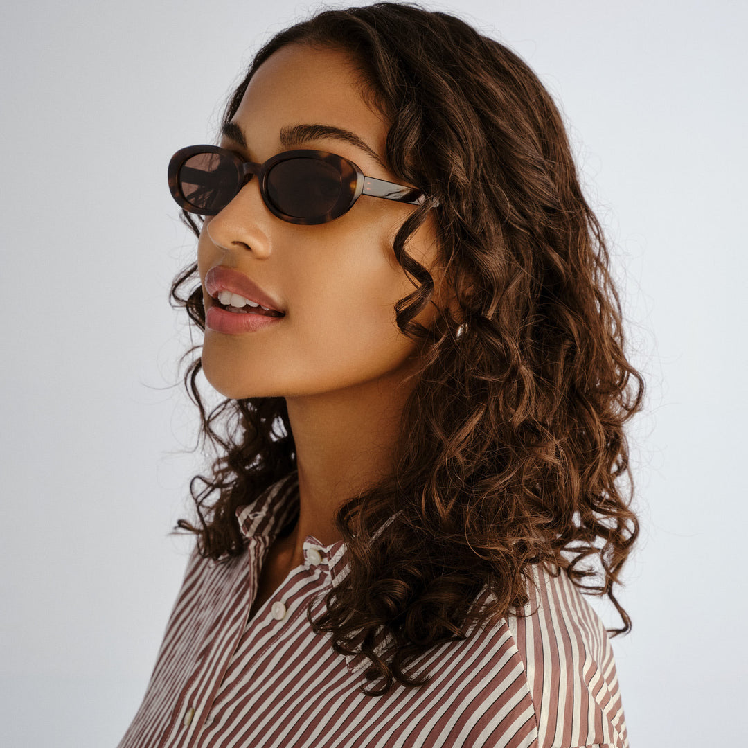 Female model wearing Northbridge sunglasses in Amber Tort, three‑quarter angle