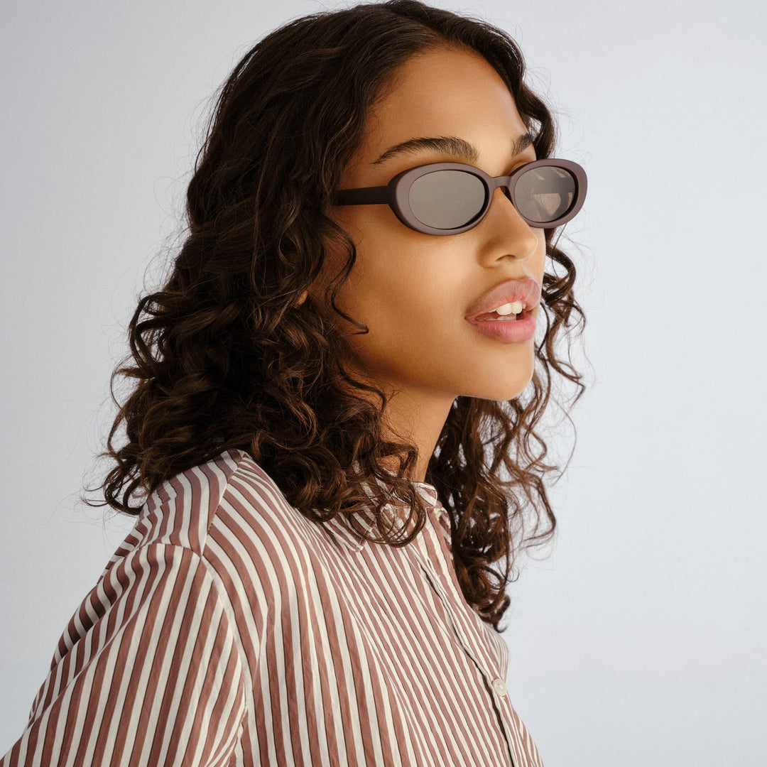 Female model wearing Northbridge sunglasses in Matte Mulberry, three‑quarter angle