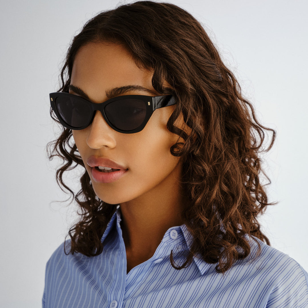 Female model wearing Swanbourne sunglasses in Black, three‑quarter angle