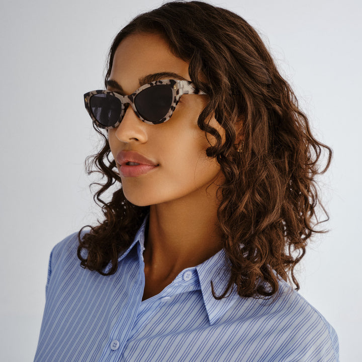 Female model wearing Swanbourne sunglasses in Graphic Tort, three‑quarter angle