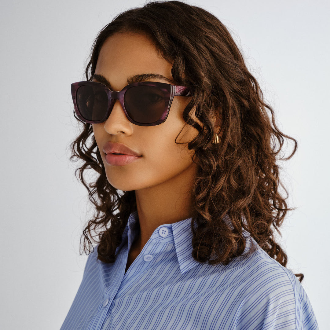 Female model wearing Teneriffe sunglasses in Purple Haze, three‑quarter angle