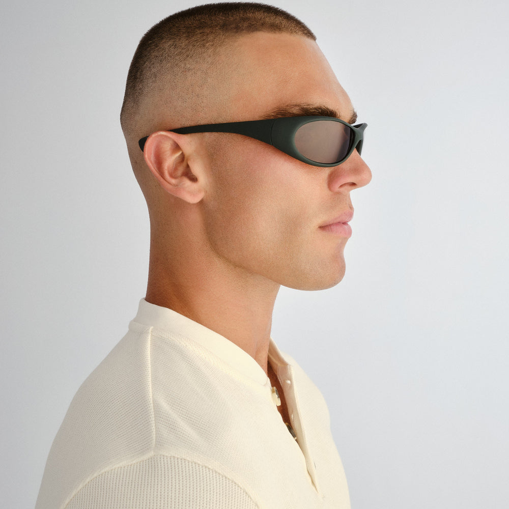 Side profile of male model wearing Logan sunglasses in Rubber Khaki