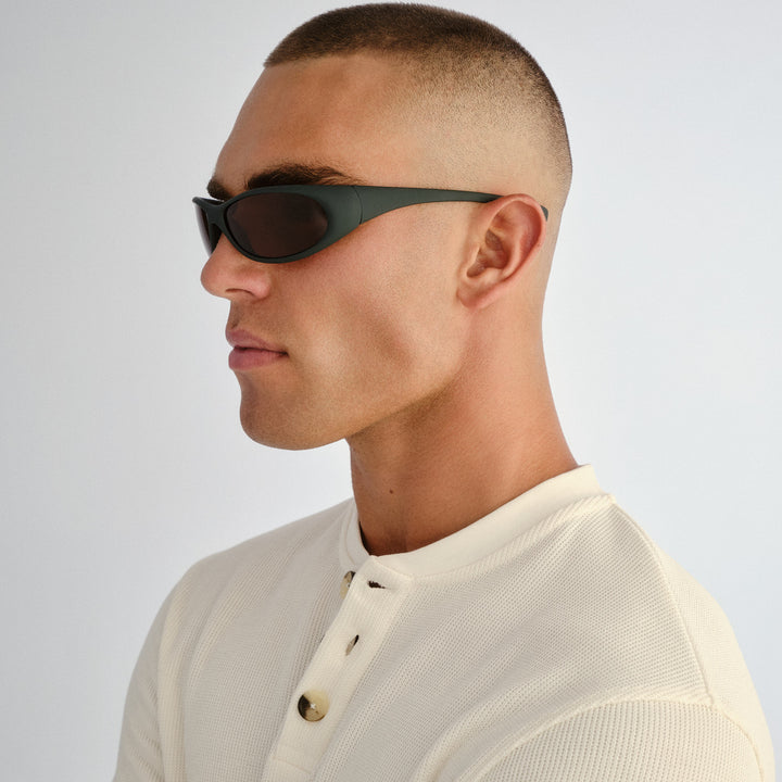 Side profile of male model wearing Logan sunglasses in Rubber Khaki