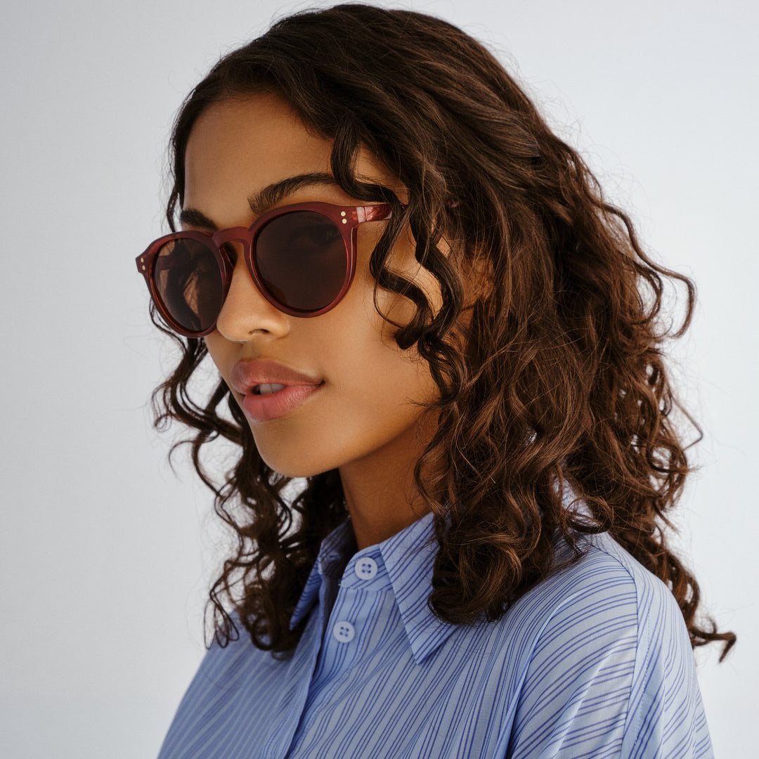 Side profile of female model wearing Bright sunglasses in Merlot