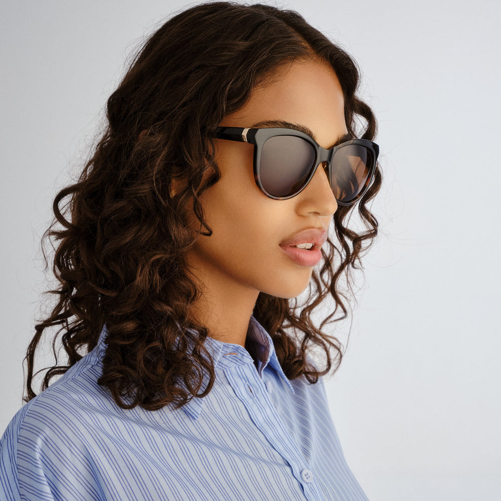 Model wearing Cancer Council Calwell sunglasses in Black/Tort Splice colourway