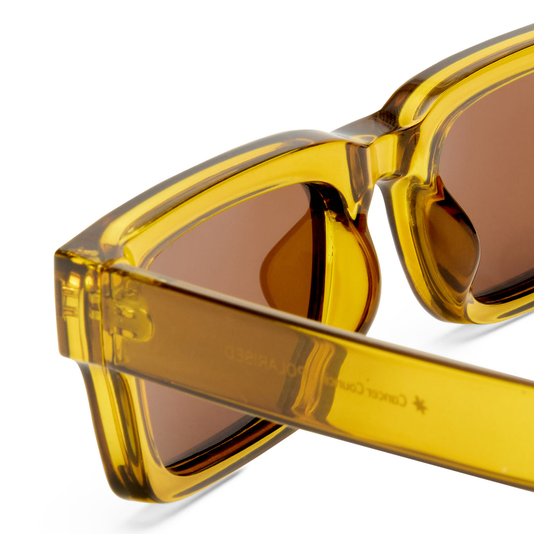 Zoomed in yellow sunglasses with brown lenses on a white background