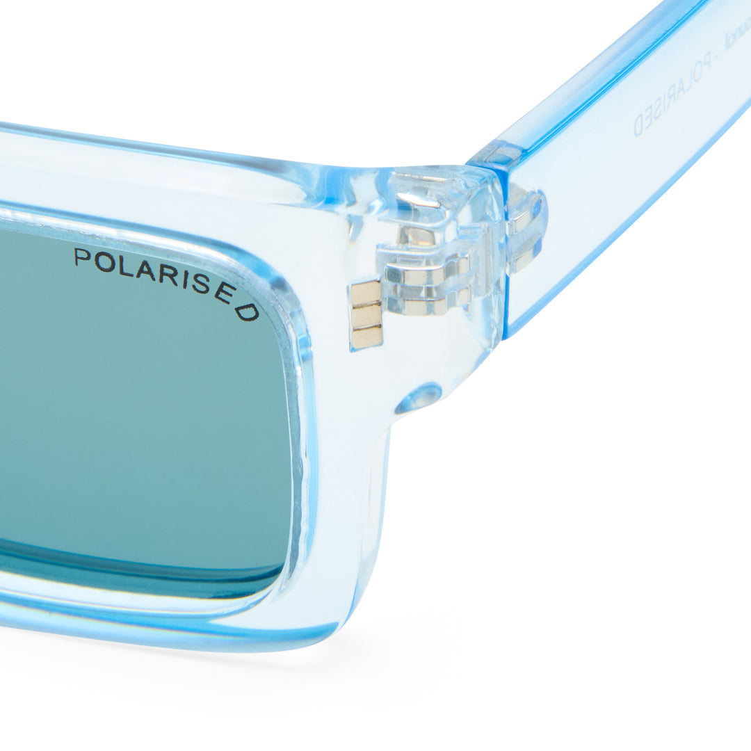 Close-up of light blue translucent Austinmer sunglasses with a matching blue lens and polarised logo on the frame.