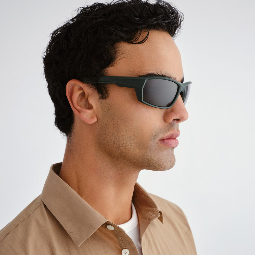 Man wearing sunglasses with a neutral background