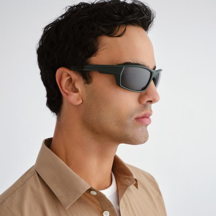 Man wearing sunglasses with a neutral background