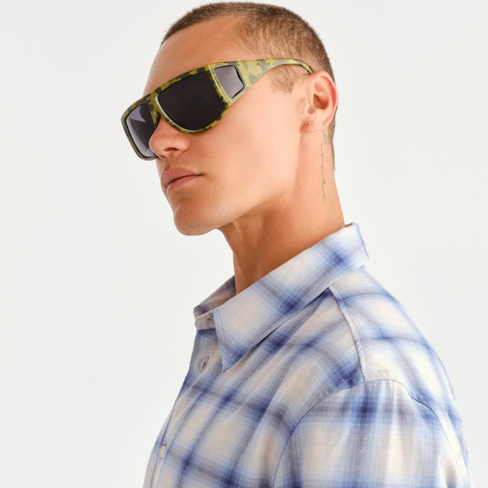A man wearing green camouflage sunglasses