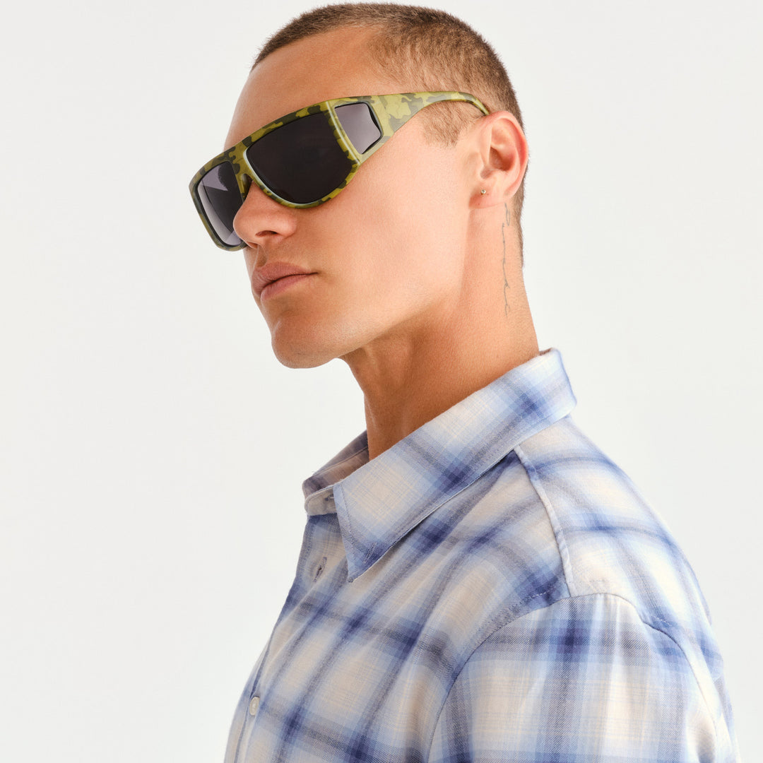A man wearing green camouflage sunglasses