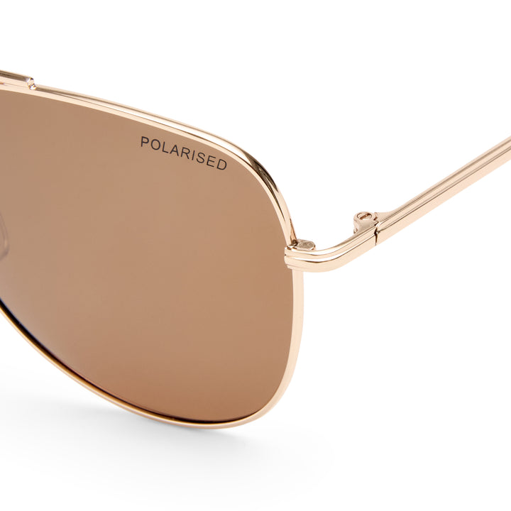 Rose gold sunglasses with brown lenses on a white background