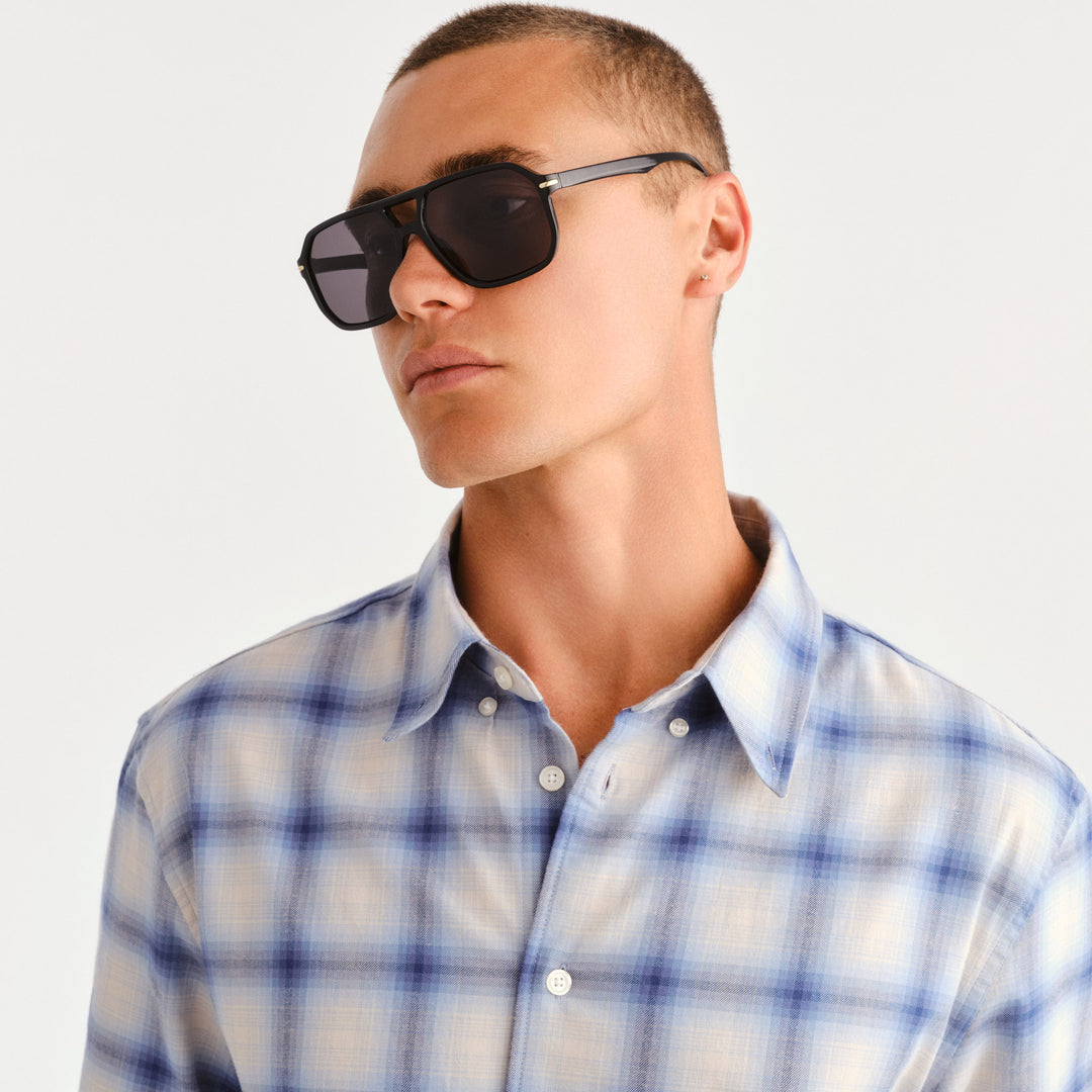 A man wearing Jensen sunglasses in black with gold accents