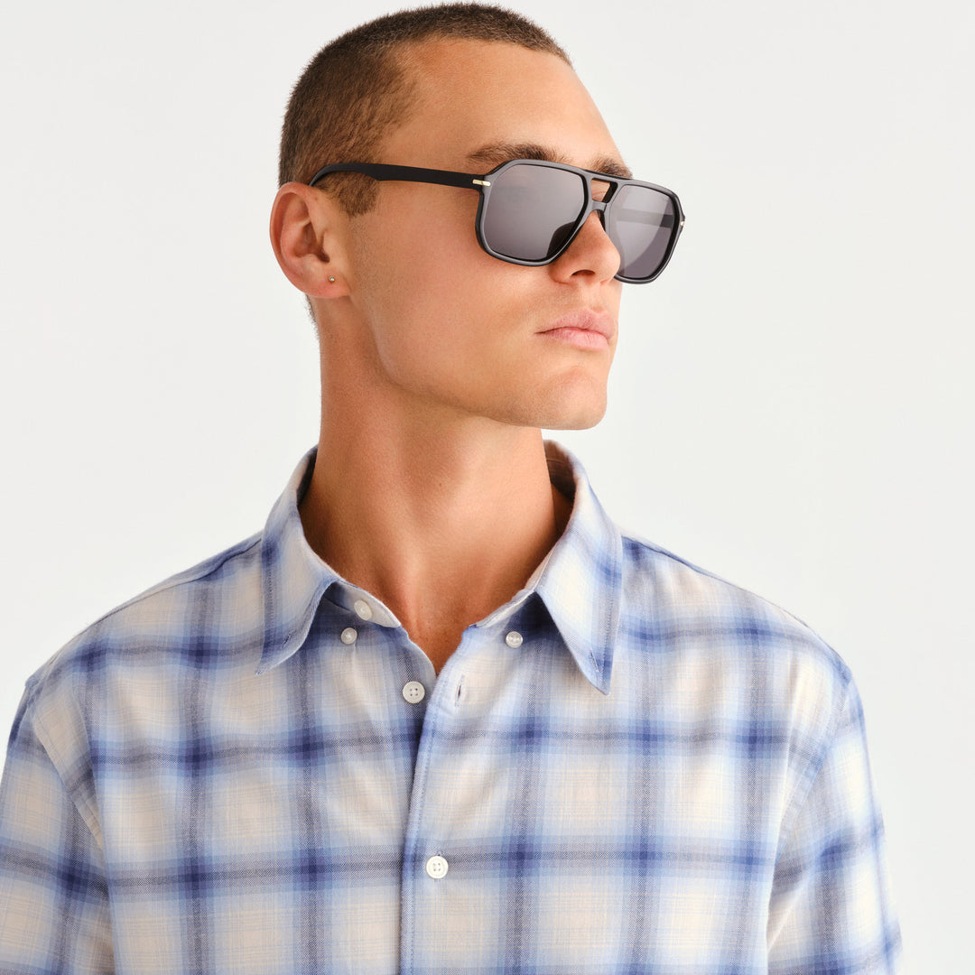 A man wearing black aviator style sunglasses