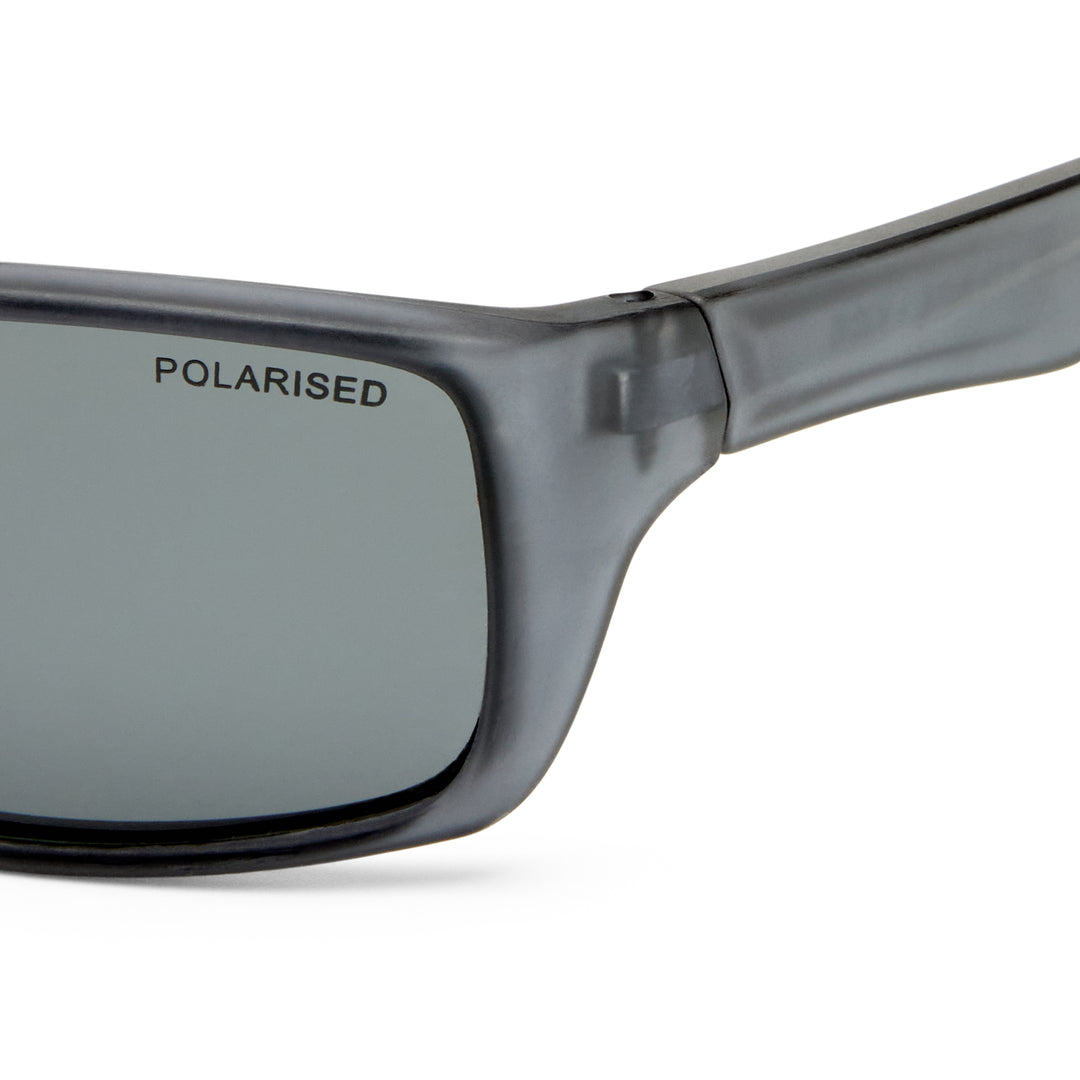 Close-up of a pair of sunglasses with a translucent dark gray frame and a gray polarized lens, featuring the word 'POLARISED' printed on the lens.