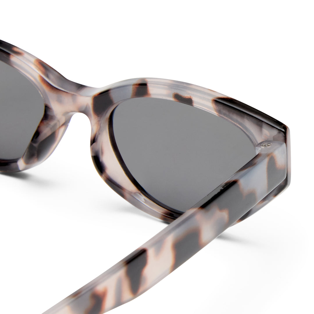 Sunglasses with tortoiseshell frame and dark lenses on a white background