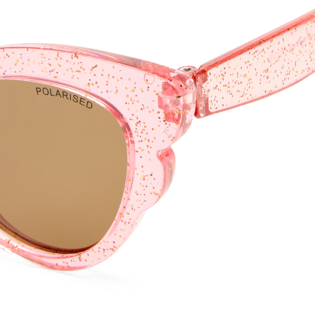 Close-up of pink translucent sunglasses with a glittery finish and brown polarized lenses. 'POLARISED' is printed on the lens.