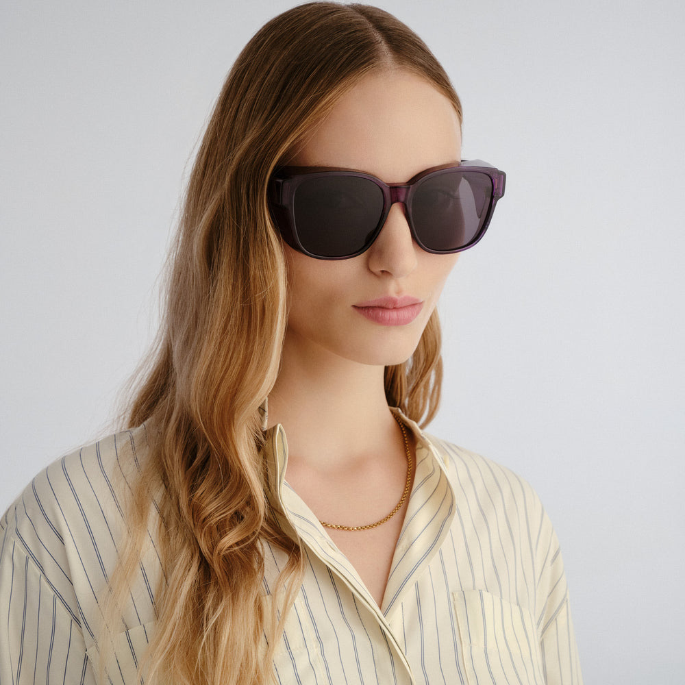 Woman wearing dark sunglasses against a light background