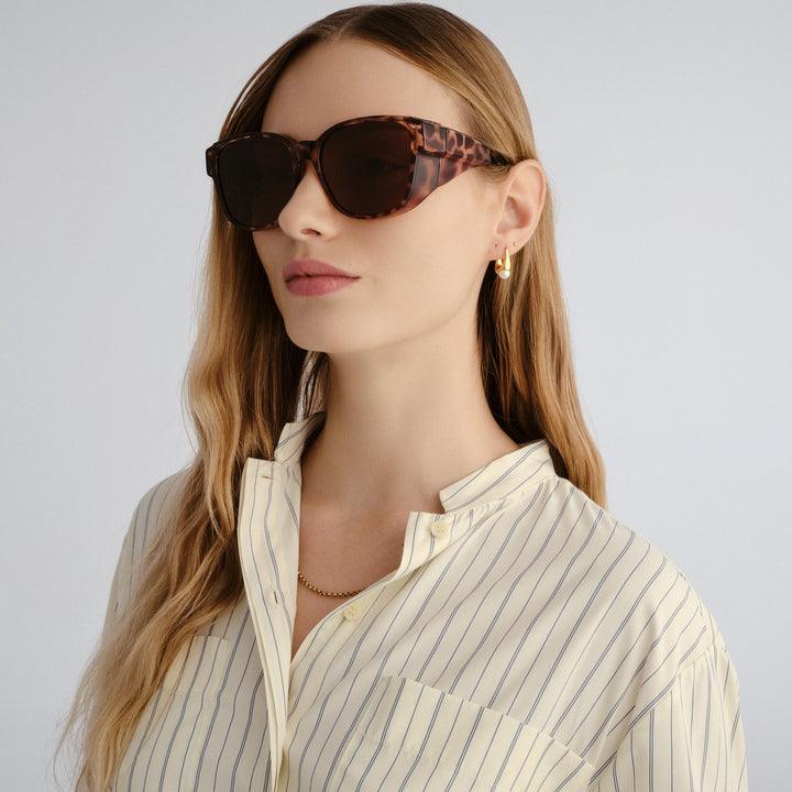 Woman wearing sunglasses with a neutral background